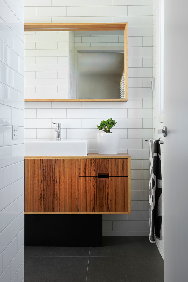 Cette photo montre une salle de bain rétro en bois brun de taille moyenne avec un placard en trompe-l'oeil et un plan de toilette en bois.