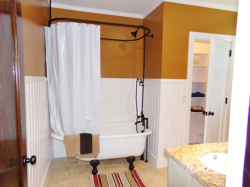 Идея дизайна: большая ванная комната в стиле кантри с накладной раковиной, белыми фасадами, столешницей из гранита, ванной на ножках, душем над ванной, оранжевыми стенами, полом из известняка и душевой кабиной