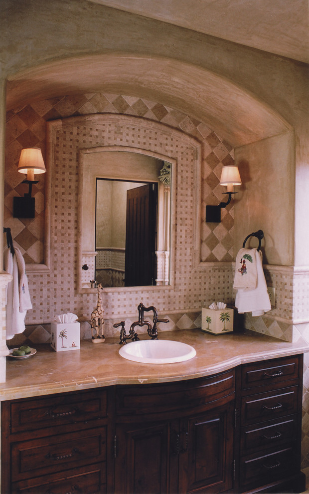 Foto di una grande stanza da bagno padronale mediterranea con lavabo da incasso, ante in legno bruno, top in granito, piastrelle beige, piastrelle in pietra e pareti beige