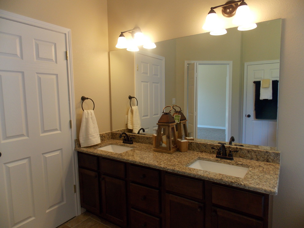 Exemple d'une grande salle de bain principale chic en bois foncé avec une vasque, un placard à porte plane, un plan de toilette en granite, une baignoire posée, une douche d'angle, WC séparés, un carrelage multicolore, des carreaux de céramique, un mur beige et un sol en carrelage de céramique.