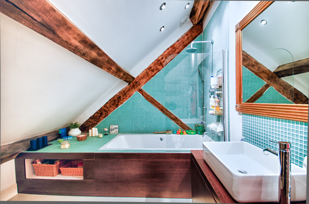 Foto på ett litet rustikt brun badrum för barn, med släta luckor, bruna skåp, ett platsbyggt badkar, en dusch/badkar-kombination, blå kakel, grön kakel, blå väggar, ett avlångt handfat, träbänkskiva och med dusch som är öppen