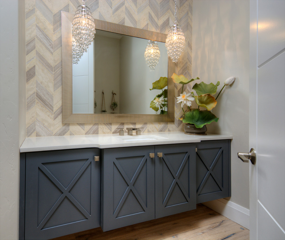 Imagen de cuarto de baño moderno de tamaño medio con armarios estilo shaker, puertas de armario grises, paredes grises, suelo de madera clara y aseo y ducha