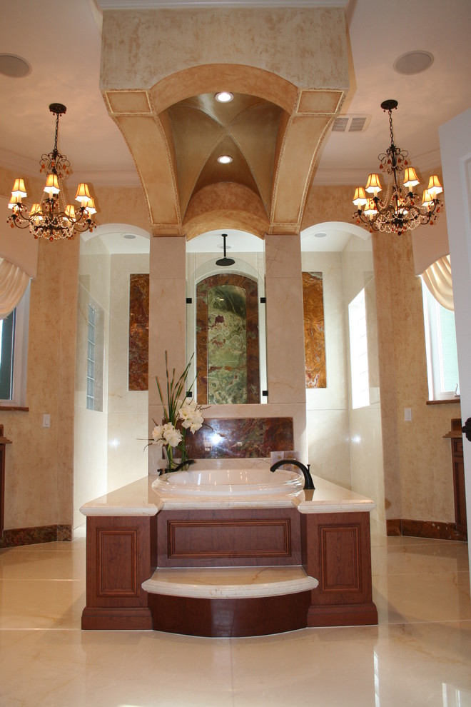 Aménagement d'une très grande salle de bain principale méditerranéenne en bois foncé avec un placard avec porte à panneau encastré, une baignoire posée, une douche ouverte, un mur beige et un sol en marbre.