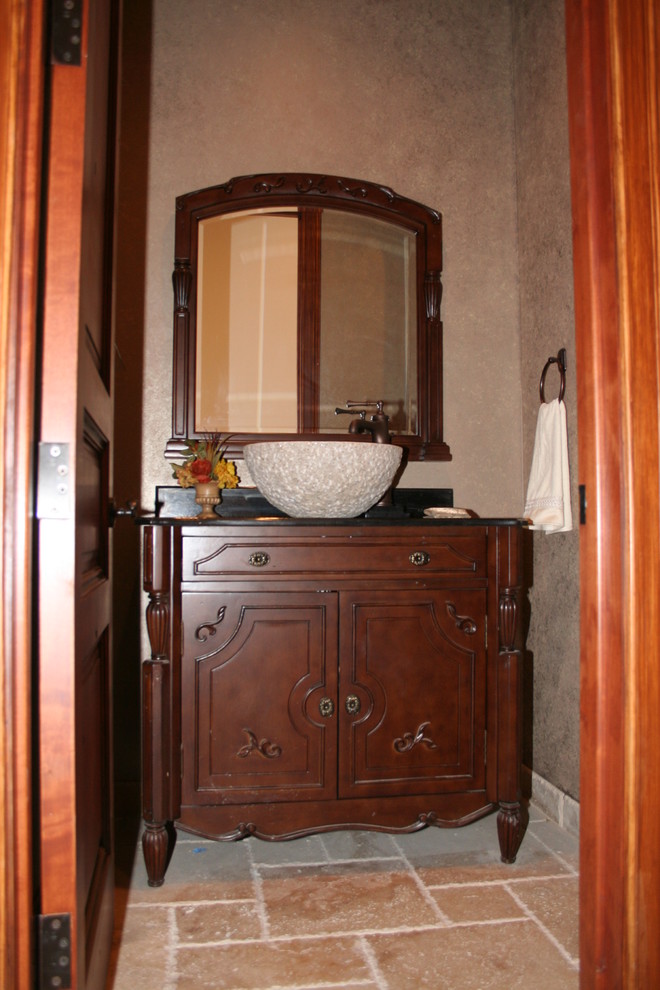 Cette image montre une petite salle d'eau design en bois foncé avec un placard en trompe-l'oeil, un mur beige, un sol en travertin, une vasque et un plan de toilette en surface solide.