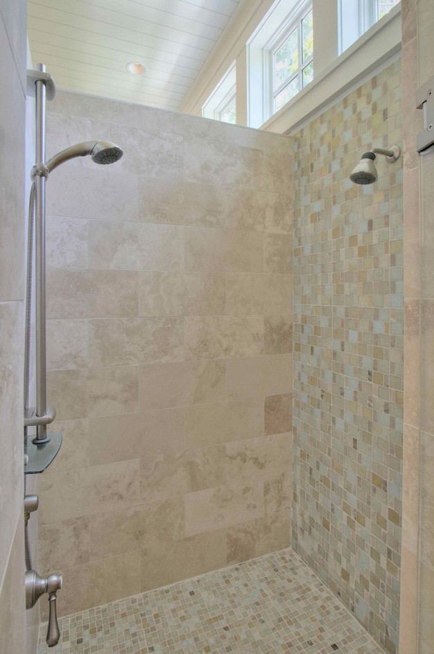 Klassisk inredning av ett stort en-suite badrum, med luckor med profilerade fronter, vita skåp, ett platsbyggt badkar, beige kakel, kakelplattor, blå väggar, kalkstensgolv, ett undermonterad handfat och bänkskiva i kalksten