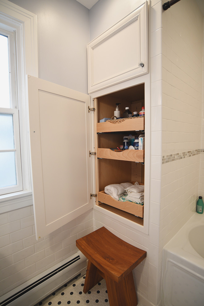 Modelo de cuarto de baño clásico de tamaño medio con lavabo tipo consola, bañera empotrada, combinación de ducha y bañera, sanitario de una pieza, baldosas y/o azulejos blancos, paredes azules y aseo y ducha