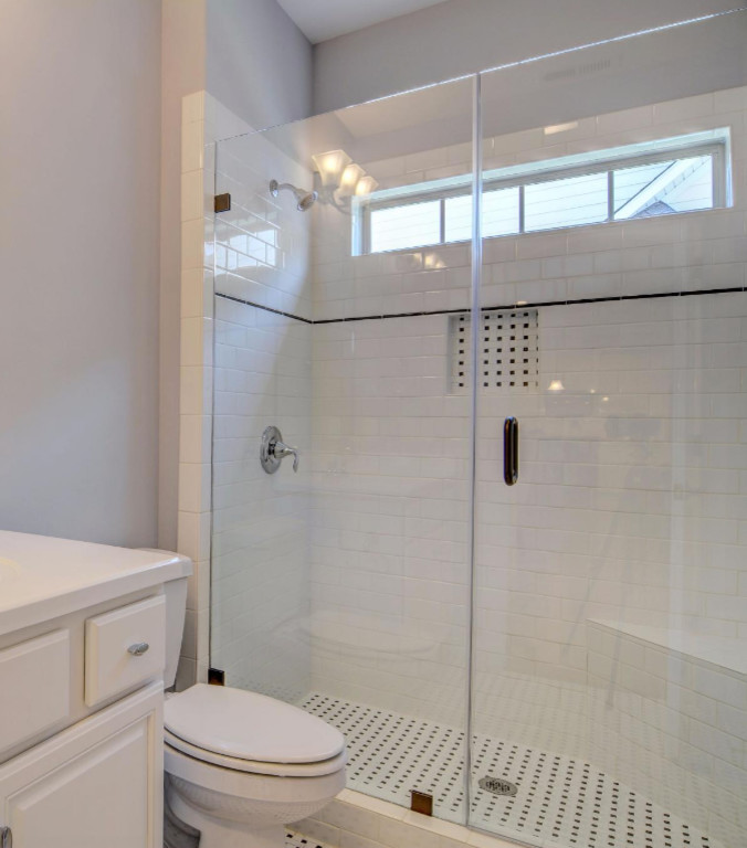 Inspiration for a mid-sized kids' white tile and subway tile ceramic tile and white floor alcove shower remodel in Other with beaded inset cabinets, white cabinets, a two-piece toilet, gray walls, an integrated sink, solid surface countertops and a hinged shower door