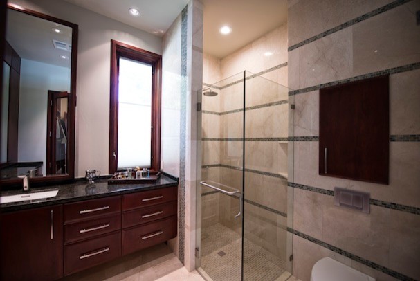 Modelo de cuarto de baño contemporáneo con armarios tipo mueble, puertas de armario de madera oscura y ducha esquinera