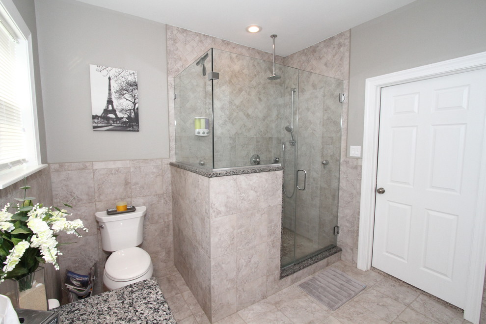 Inspiration for a mid-sized timeless master gray tile and porcelain tile porcelain tile corner shower remodel in Philadelphia with an undermount sink, raised-panel cabinets, white cabinets, granite countertops, a two-piece toilet and gray walls