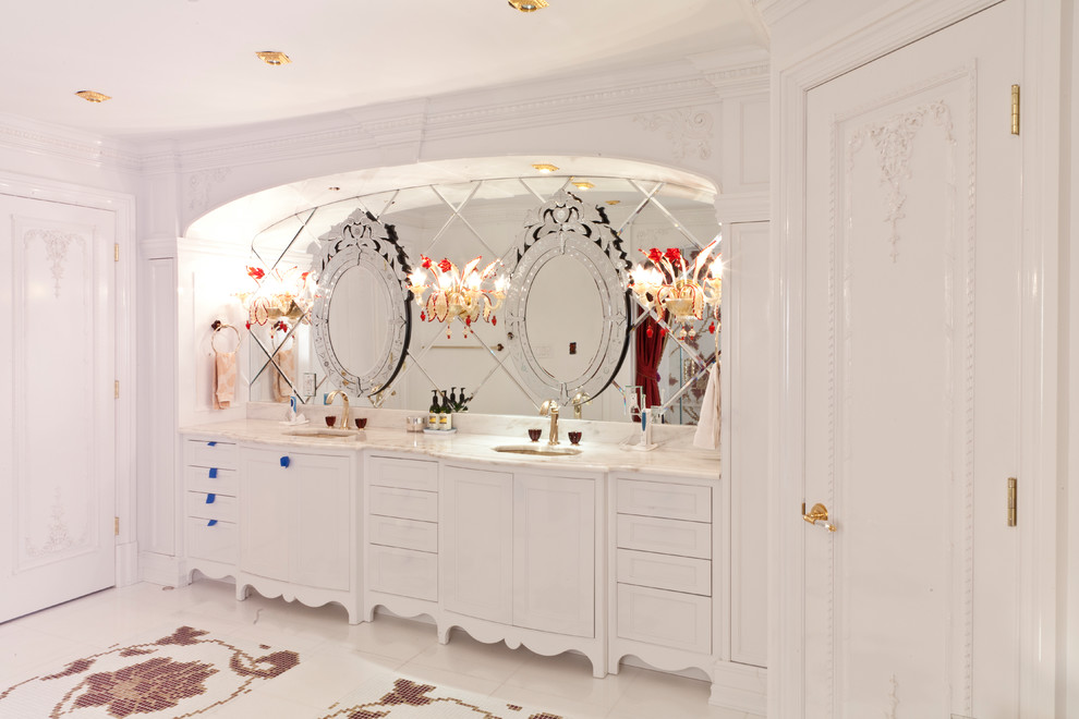 На фото: огромная главная ванная комната в викторианском стиле с фасадами с выступающей филенкой, белыми фасадами, серой плиткой, зеркальной плиткой, белыми стенами, полом из мозаичной плитки, врезной раковиной, мраморной столешницей, разноцветным полом и белой столешницей
