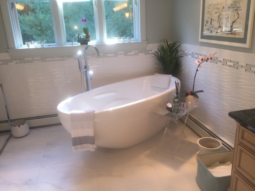 Medium sized classic ensuite bathroom in Providence with recessed-panel cabinets, light wood cabinets, a freestanding bath, an alcove shower, white tiles, porcelain tiles, grey walls, marble flooring, a vessel sink, soapstone worktops, grey floors, a hinged door and black worktops.