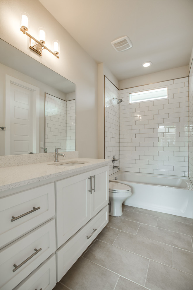 Design ideas for a contemporary family bathroom in Dallas with a submerged sink, shaker cabinets, white cabinets, quartz worktops, a built-in bath, a shower/bath combination, white tiles, ceramic tiles, white walls and ceramic flooring.