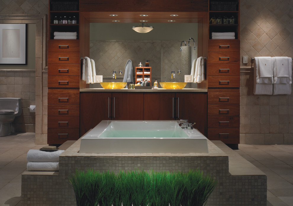 Inspiration for a large world-inspired ensuite bathroom in Toronto with flat-panel cabinets, dark wood cabinets, a built-in bath, brown tiles, travertine tiles, beige walls, travertine flooring, a vessel sink, concrete worktops, brown floors and grey worktops.