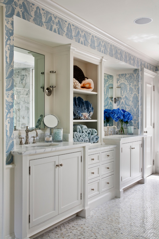 Klassisk inredning av ett en-suite badrum, med ett undermonterad handfat, vita skåp, marmorbänkskiva, blå väggar, mosaikgolv och luckor med infälld panel