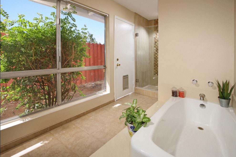 Inspiration for a large tropical master ceramic tile bathroom remodel in Austin with medium tone wood cabinets, a two-piece toilet, beige walls, an undermount sink, raised-panel cabinets and solid surface countertops