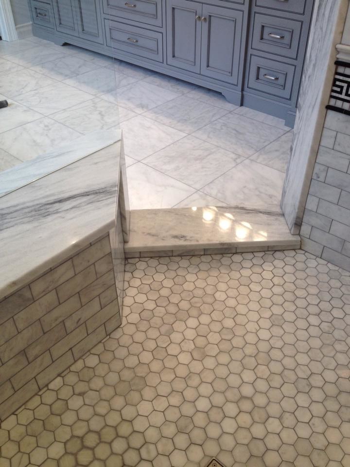 Inspiration for a large beige tile corner shower remodel in Other with gray cabinets and white walls