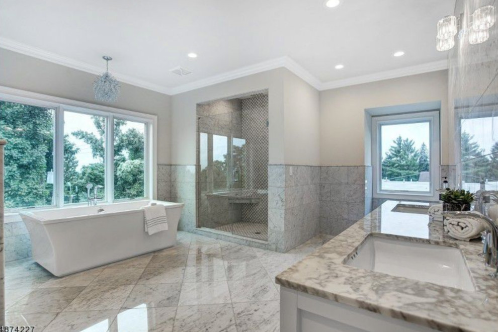 Huge transitional master gray tile and marble tile marble floor and beige floor bathroom photo in Newark with shaker cabinets, white cabinets, a two-piece toilet, beige walls, an undermount sink, marble countertops, a hinged shower door and beige countertops