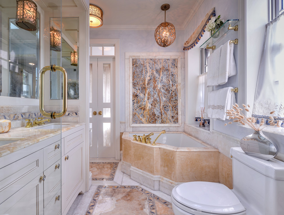 На фото: главная ванная комната в классическом стиле с фасадами с утопленной филенкой, бежевыми фасадами, угловой ванной, двойным душем, унитазом-моноблоком, разноцветной плиткой, мраморной плиткой, синими стенами, мраморным полом, врезной раковиной, столешницей из оникса, разноцветным полом и душем с распашными дверями