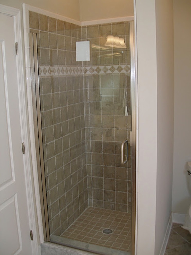 Medium sized classic ensuite bathroom in Jacksonville with raised-panel cabinets, dark wood cabinets, a corner bath, an alcove shower, brown tiles, porcelain tiles, beige walls, porcelain flooring, an integrated sink, solid surface worktops, brown floors, a hinged door and white worktops.