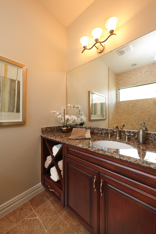 Transitional beige tile and ceramic tile porcelain tile and beige floor bathroom photo in Orlando with raised-panel cabinets, medium tone wood cabinets, beige walls, a vessel sink and soapstone countertops
