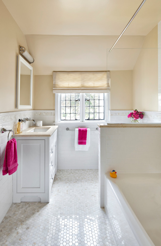 На фото: детская ванная комната в современном стиле с врезной раковиной, фасадами в стиле шейкер, белыми фасадами, мраморной столешницей, ванной в нише, душем в нише, белой плиткой и плиткой кабанчик с