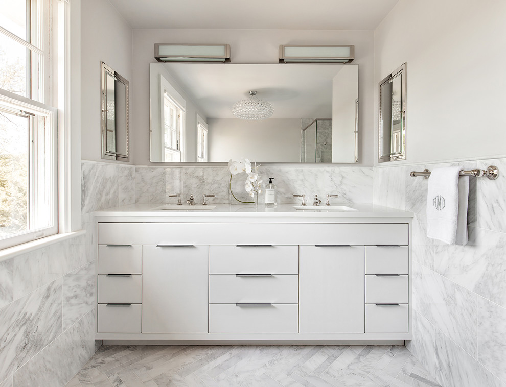 Réalisation d'une salle de bain tradition de taille moyenne avec un placard à porte plane, des portes de placard blanches, un sol en marbre, un lavabo encastré et un plan de toilette blanc.