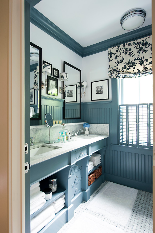 Inredning av ett klassiskt badrum, med öppna hyllor, marmorbänkskiva och blå skåp