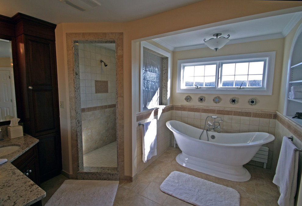 Пример оригинального дизайна: большая главная ванная комната в морском стиле с врезной раковиной, фасадами с выступающей филенкой, темными деревянными фасадами, столешницей из гранита, отдельно стоящей ванной, душем в нише, бежевой плиткой, керамической плиткой, бежевыми стенами и полом из травертина