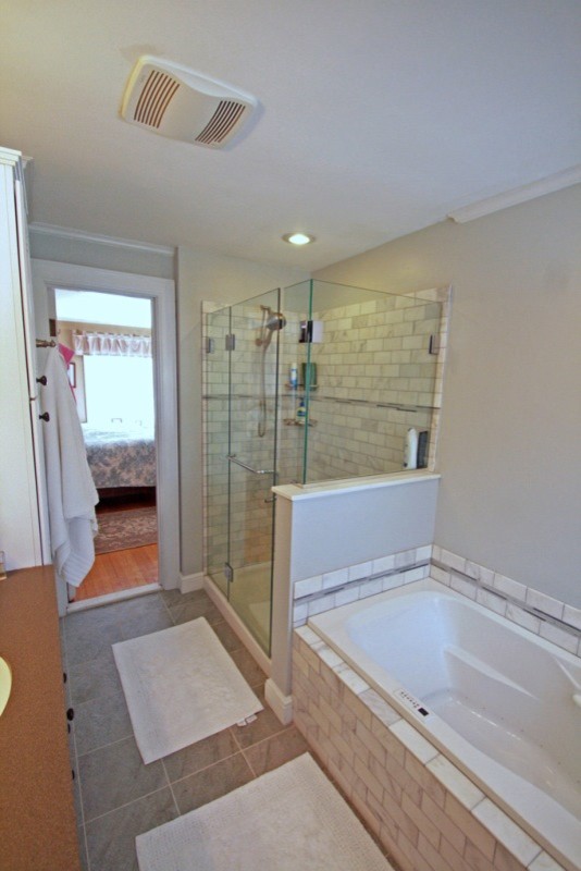Bild på ett mellanstort funkis en-suite badrum, med ett undermonterad handfat, bänkskiva i kvarts, ett platsbyggt badkar, en hörndusch, grå kakel, stenkakel, grå väggar och klinkergolv i porslin