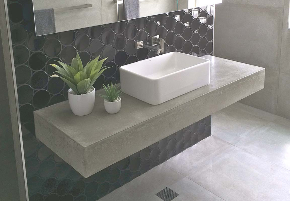 Exemple d'une salle de bain tendance avec un carrelage noir, un mur noir, sol en béton ciré et un plan de toilette en béton.