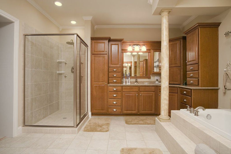 Foto de cuarto de baño tradicional grande con puertas de armario de madera oscura, encimera de granito, combinación de ducha y bañera, baldosas y/o azulejos beige, paredes beige y suelo de baldosas de cerámica