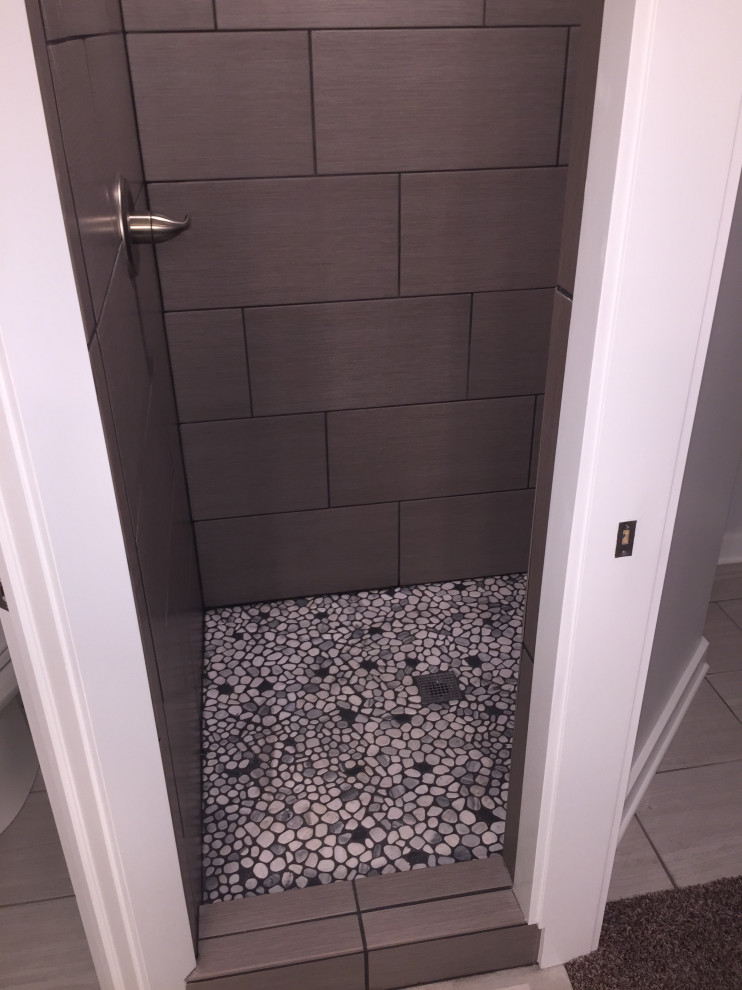 Exempel på ett mellanstort industriellt vit vitt en-suite badrum, med släta luckor, grå skåp, ett platsbyggt badkar, en öppen dusch, en toalettstol med separat cisternkåpa, grå kakel, kakel i småsten, blå väggar, laminatgolv, ett nedsänkt handfat, bänkskiva i akrylsten, grått golv och med dusch som är öppen