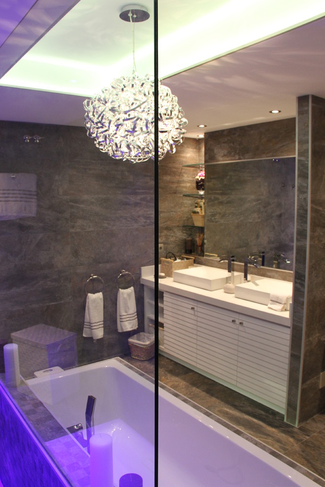 Modelo de cuarto de baño principal contemporáneo de tamaño medio con puertas de armario blancas, bañera empotrada, combinación de ducha y bañera y lavabo sobreencimera