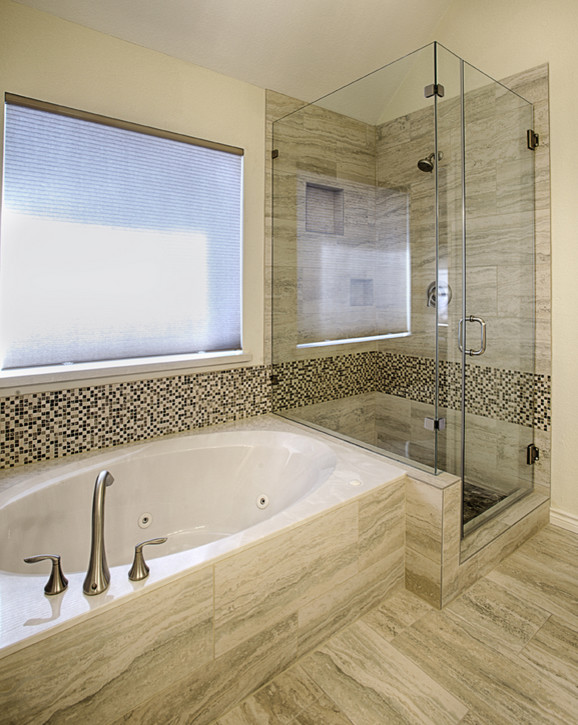 Ejemplo de cuarto de baño clásico con bañera esquinera, ducha esquinera, baldosas y/o azulejos grises y suelo de baldosas tipo guijarro
