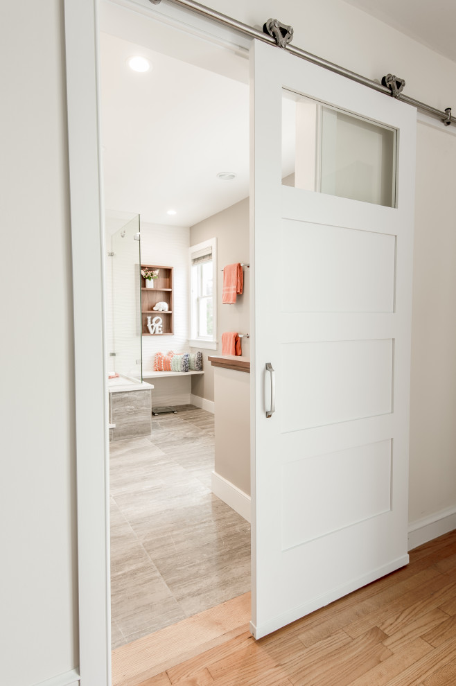 Foto de cuarto de baño principal actual de tamaño medio con armarios con paneles lisos, puertas de armario grises, ducha esquinera, sanitario de una pieza, baldosas y/o azulejos blancos, baldosas y/o azulejos de cerámica, paredes beige, suelo de baldosas de cerámica, lavabo bajoencimera, encimera de cuarzo compacto, suelo beige, ducha con puerta con bisagras y encimeras blancas