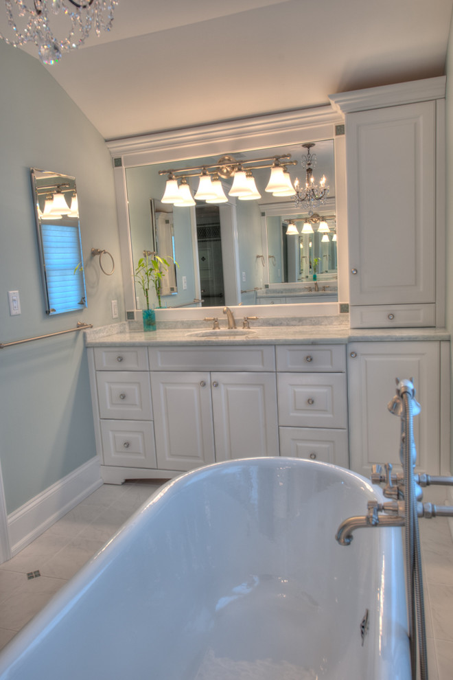 Large elegant master porcelain tile claw-foot bathtub photo in Philadelphia with an undermount sink, raised-panel cabinets, white cabinets and marble countertops
