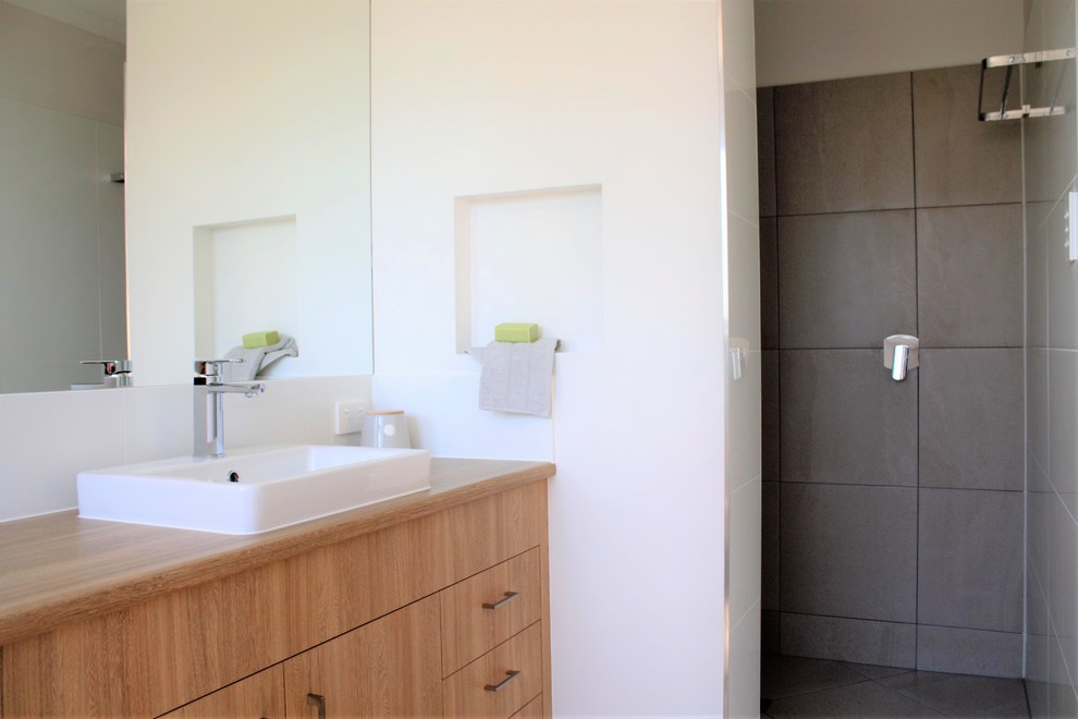 Стильный дизайн: главная ванная комната в современном стиле с плоскими фасадами, светлыми деревянными фасадами, душем в нише и столешницей из ламината - последний тренд