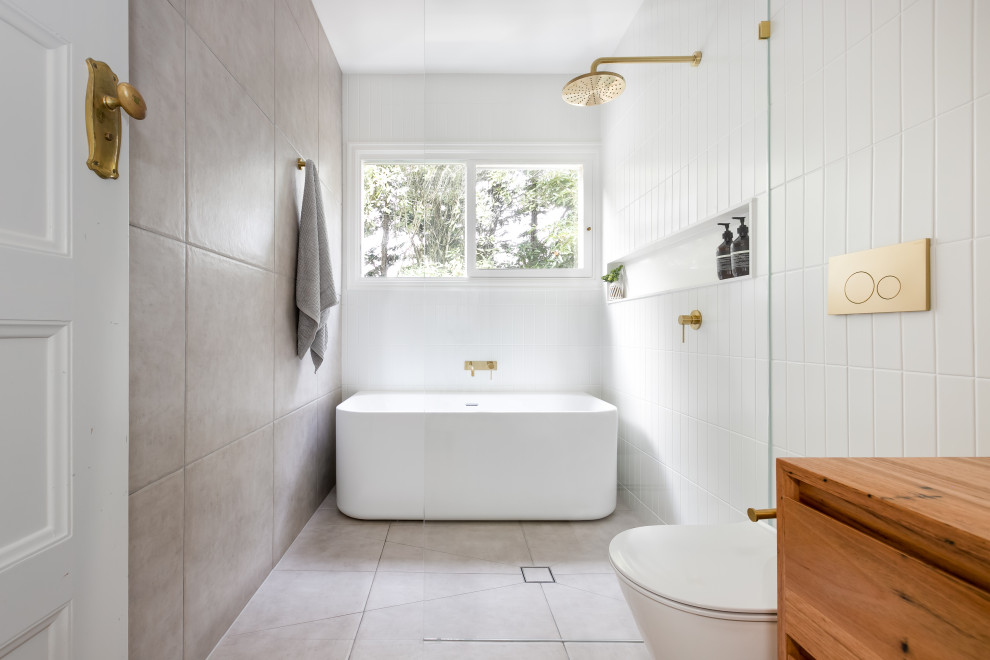 Réalisation d'une salle de bain design en bois brun avec un placard à porte plane, une baignoire indépendante, un espace douche bain, un carrelage blanc, un plan de toilette en bois, un sol gris, aucune cabine et un plan de toilette marron.
