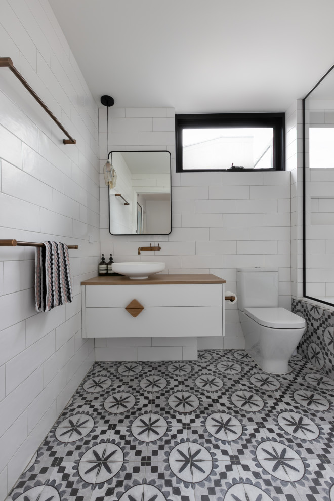Diseño de cuarto de baño único y flotante contemporáneo con armarios con paneles lisos, puertas de armario blancas, baldosas y/o azulejos blancos, lavabo sobreencimera, encimera de madera, suelo gris y encimeras marrones