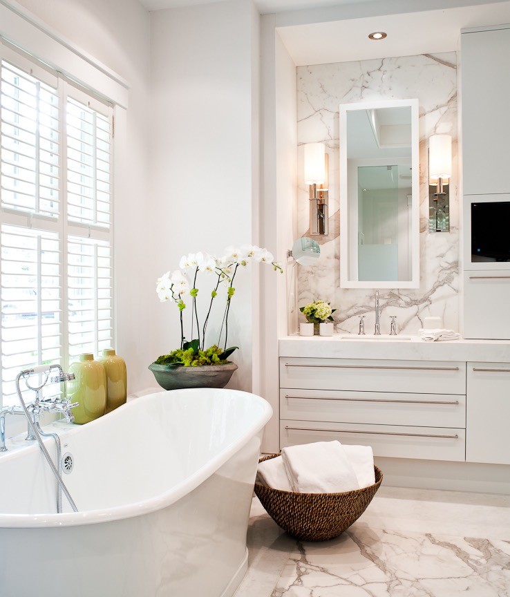 Imagen de cuarto de baño actual de tamaño medio con armarios con paneles lisos, bañera exenta, paredes blancas y lavabo bajoencimera