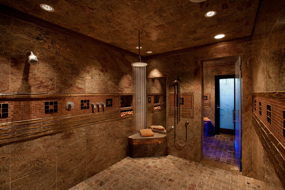 This is an example of a traditional bathroom in Phoenix with a built-in shower, brown tiles, stone tiles, brown floors, brown walls and a hinged door.