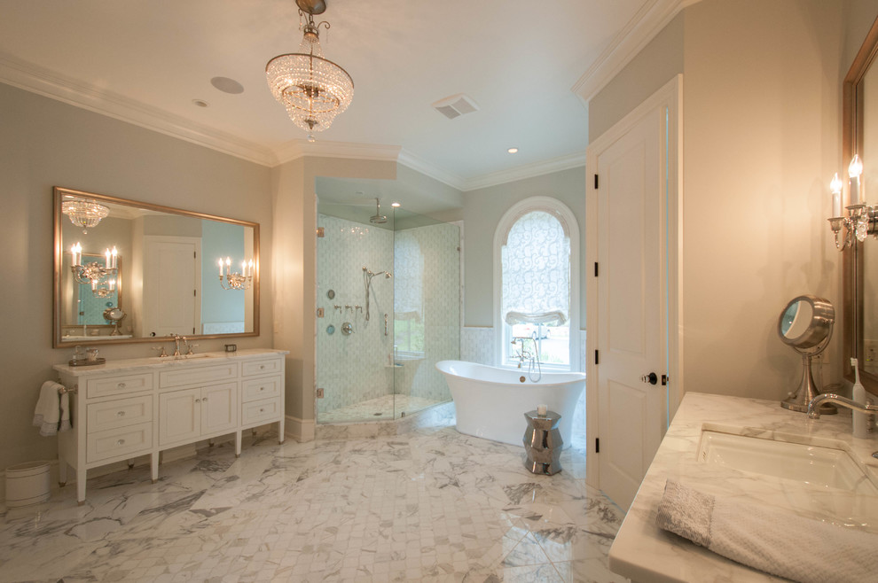 Idées déco pour une très grande salle de bain principale classique avec un placard à porte shaker, des portes de placard blanches, une baignoire indépendante, une douche d'angle, un carrelage blanc, un mur beige, un sol en marbre, un lavabo encastré, un plan de toilette en marbre, un sol blanc et une cabine de douche à porte battante.