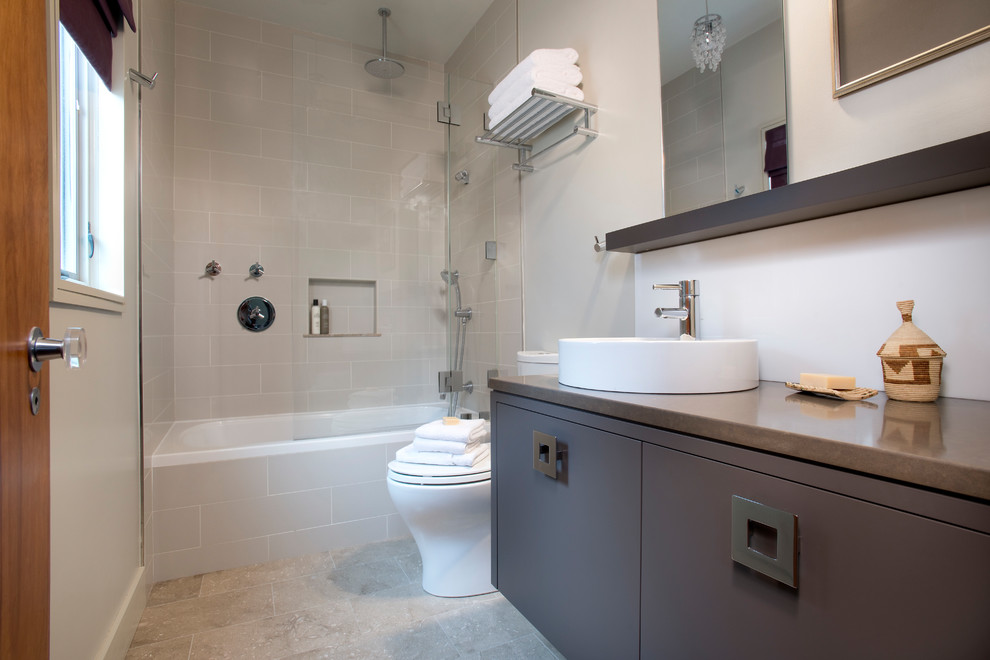 Example of a small minimalist kids' gray tile and ceramic tile limestone floor and gray floor bathroom design in Boston with flat-panel cabinets, brown cabinets, a two-piece toilet, gray walls, a vessel sink, quartz countertops and a hinged shower door