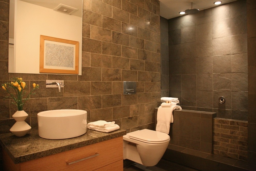 Idées déco pour une salle de bain moderne avec une vasque, du carrelage en ardoise et un mur en pierre.