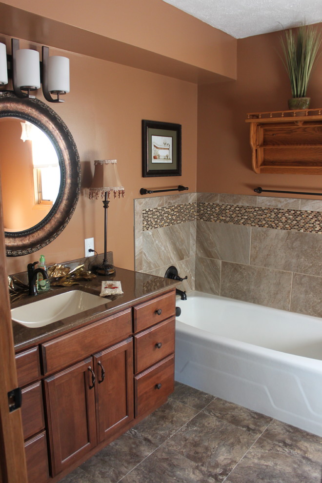 Immagine di una stanza da bagno design con lavabo integrato, ante in legno scuro, top in onice, vasca ad angolo, WC monopezzo, piastrelle blu, piastrelle di vetro e pareti arancioni