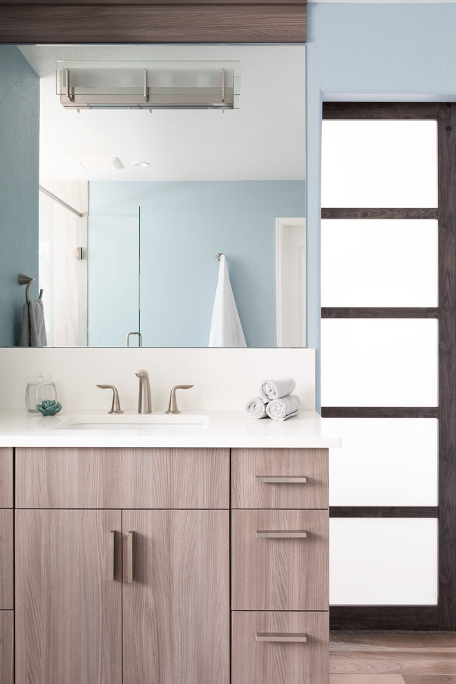 Immagine di una stanza da bagno padronale moderna di medie dimensioni con ante marroni, doccia aperta, piastrelle blu, pareti blu, lavabo a consolle, porta doccia a battente e top bianco