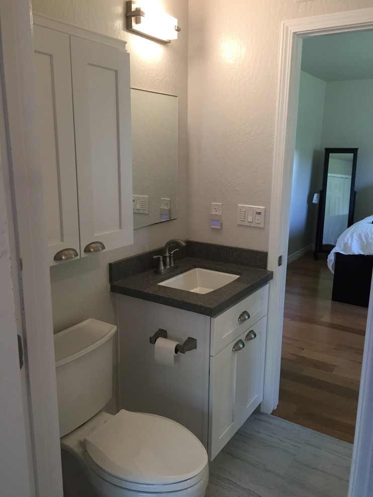 This is an example of a medium sized classic ensuite bathroom in Sacramento with shaker cabinets, white cabinets, an alcove shower, a two-piece toilet, white tiles, ceramic tiles, porcelain flooring, a submerged sink and engineered stone worktops.