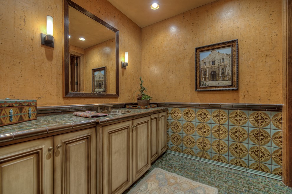 Foto di una stanza da bagno stile americano di medie dimensioni con ante con bugna sagomata, ante in legno scuro, piastrelle verdi, piastrelle in ceramica, lavabo sottopiano, top piastrellato, pareti arancioni e pavimento con piastrelle in ceramica