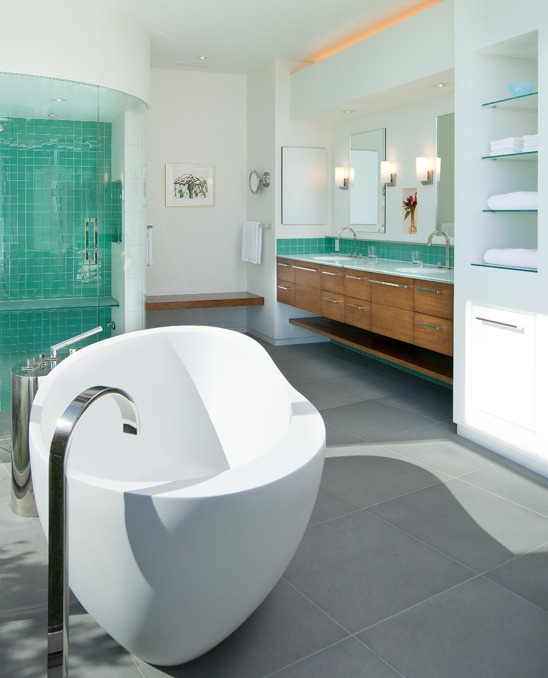 На фото: большая главная ванная комната в современном стиле с плоскими фасадами, светлыми деревянными фасадами, зеленой плиткой, стеклянной столешницей, отдельно стоящей ванной, душем в нише, керамической плиткой, белыми стенами, полом из цементной плитки и врезной раковиной