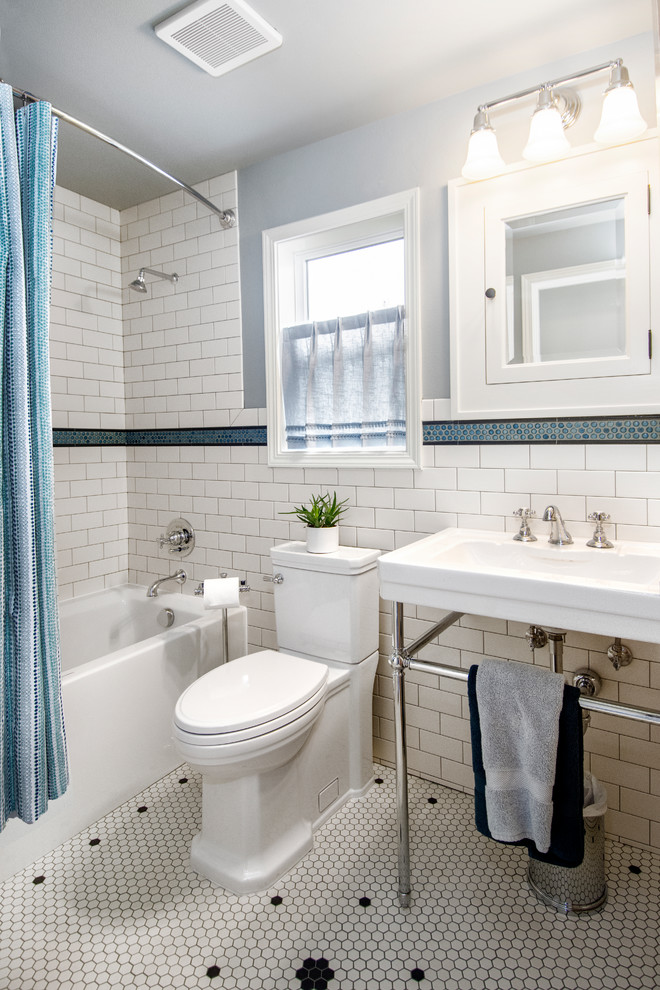 Foto på ett mellanstort vintage badrum, med ett badkar i en alkov, en dusch/badkar-kombination, en toalettstol med hel cisternkåpa, vit kakel, keramikplattor, blå väggar, klinkergolv i keramik, ett konsol handfat, vitt golv och dusch med duschdraperi